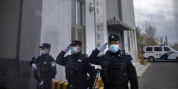 Police officers guard an entrance to a Uyghur Detention Center