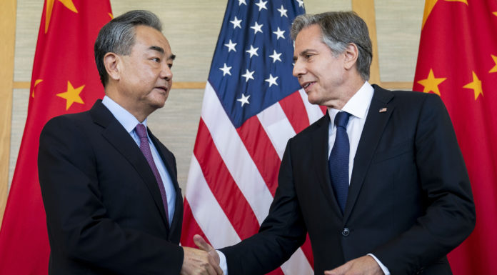 U.S. Secretary of State Antony Blinken shakes hands with China's Foreign Minister Wang Yi (Photo via AP)