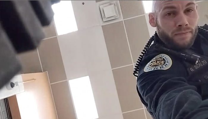 A Memphis Metro Police Officer picks up the apparent phone used by alleged school shooter Solomon Henderson to livestream a Jan. 22 school shooting. PHOTO: Screenshot from camera footage