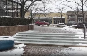 A photo taken at the approximate position of one of the deceased victims. Ross Cosmetics, where Bobby Crimo is alleged to have been shooting from, is across the street and to the left, completely obscured by Walker Bros restaurant.