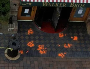 Numbers mark where bullets impacted the sidewalk in front of Walker Bros restaurant.